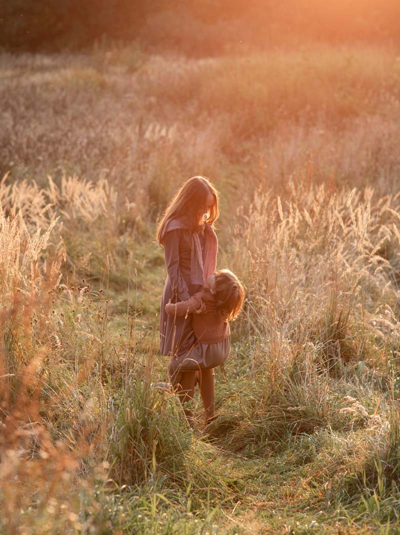 Mother and child in field during sunset