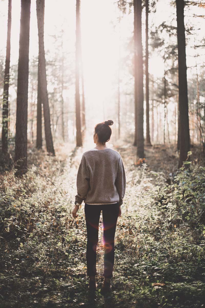 Rear view of woman standing in a forest