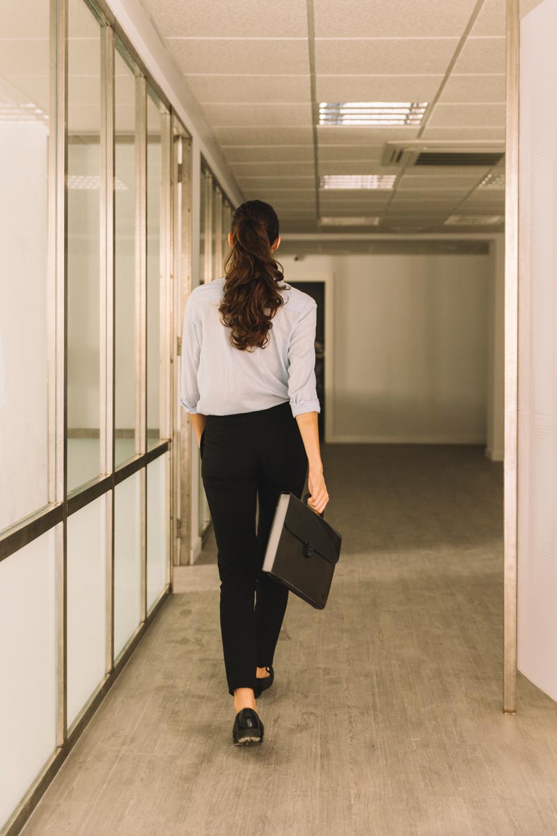 Woman office worker walking through hallway
